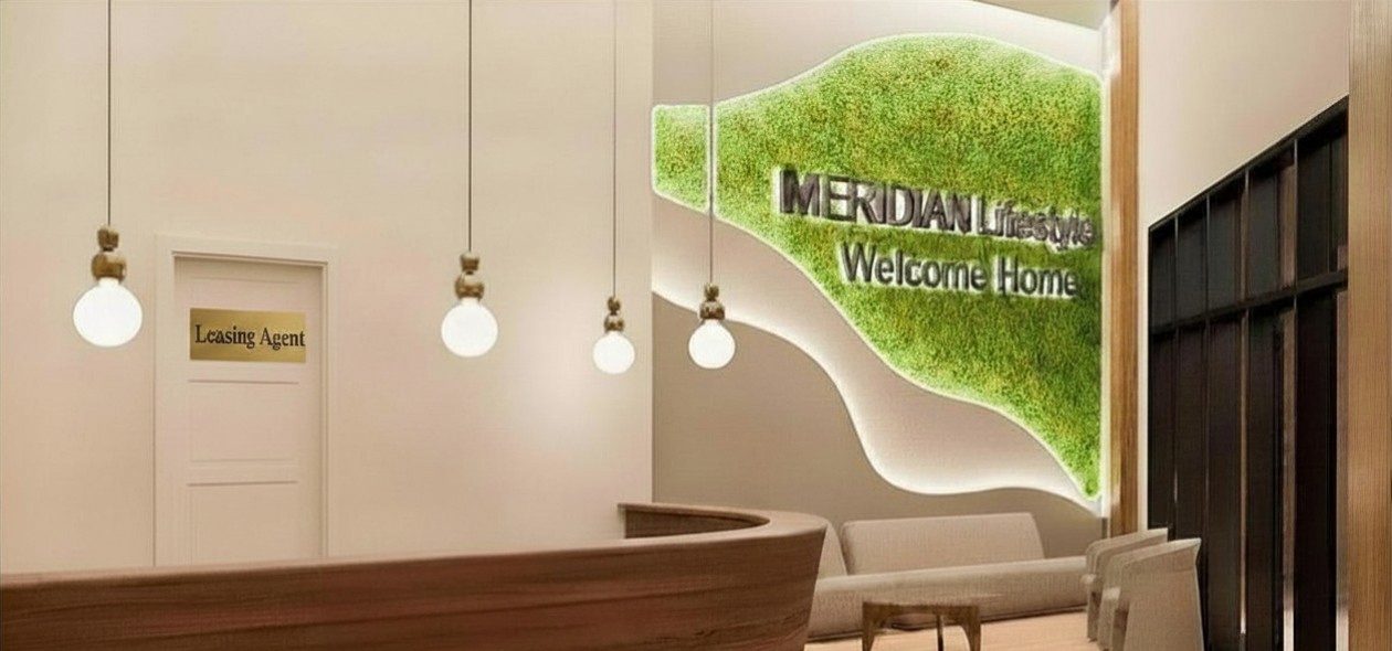The lobby reception: a curved wood desk, warm pendant lights, and a living moss wall.